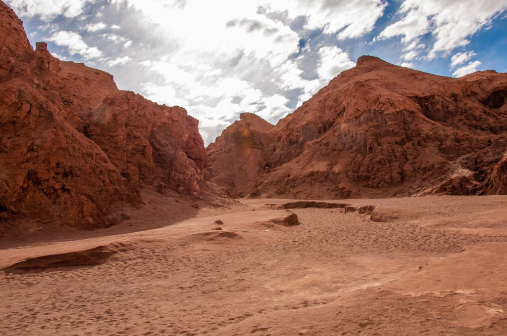 Canyon de roche rouge et de sable dans le désert d'Atacama sous un ciel nuageux