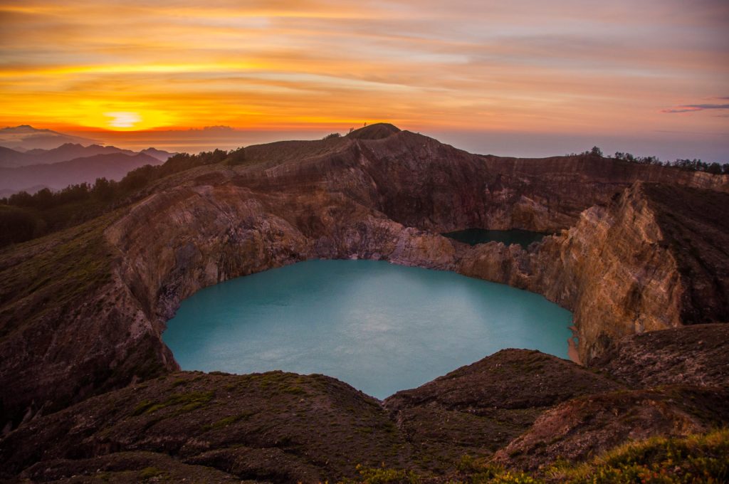 Les lacs colorés du volcan Kelimutu au lever du soleil, mer de collines à l'horizon