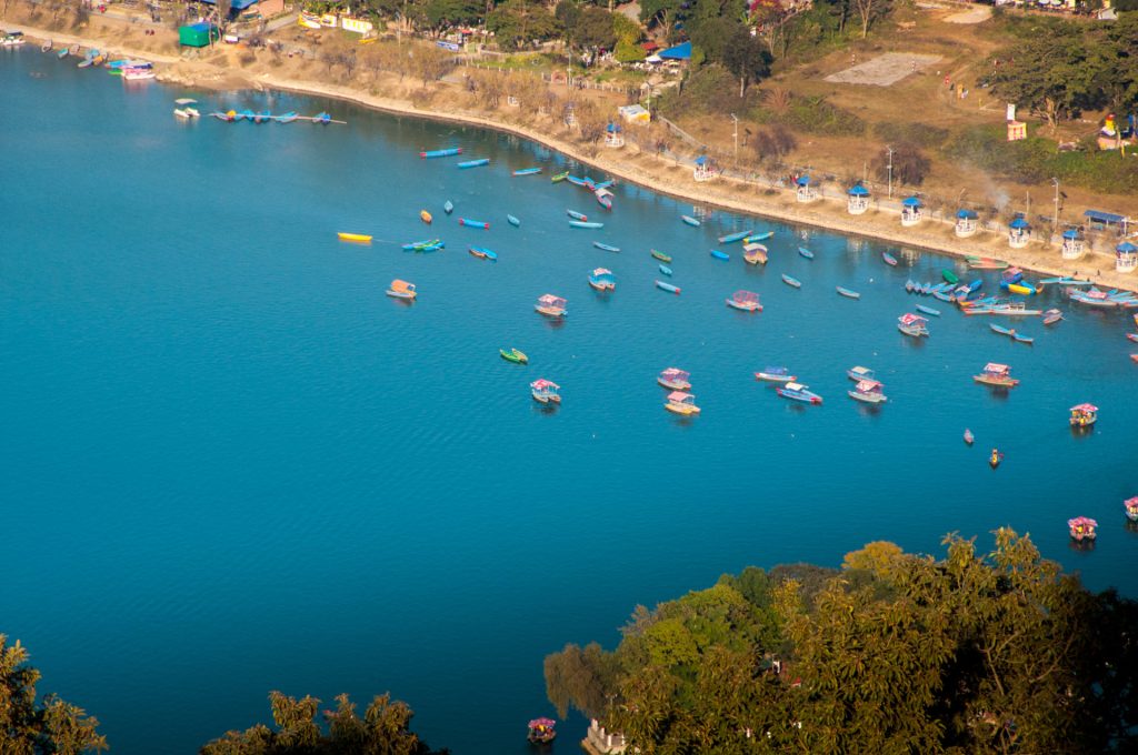 Vue plongeante sur des dizaines de barques colorées amarrées le long du lac Phewa